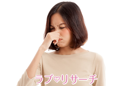 女性が鼻をつまんでいる
