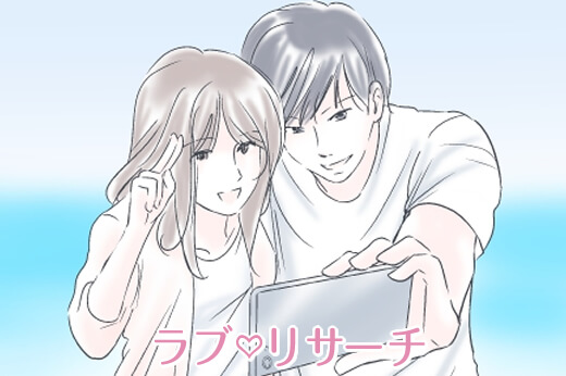 海をバックに男女が一緒に写真を撮っている