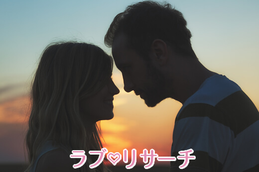 夕日をバックに男女が向かい合っている